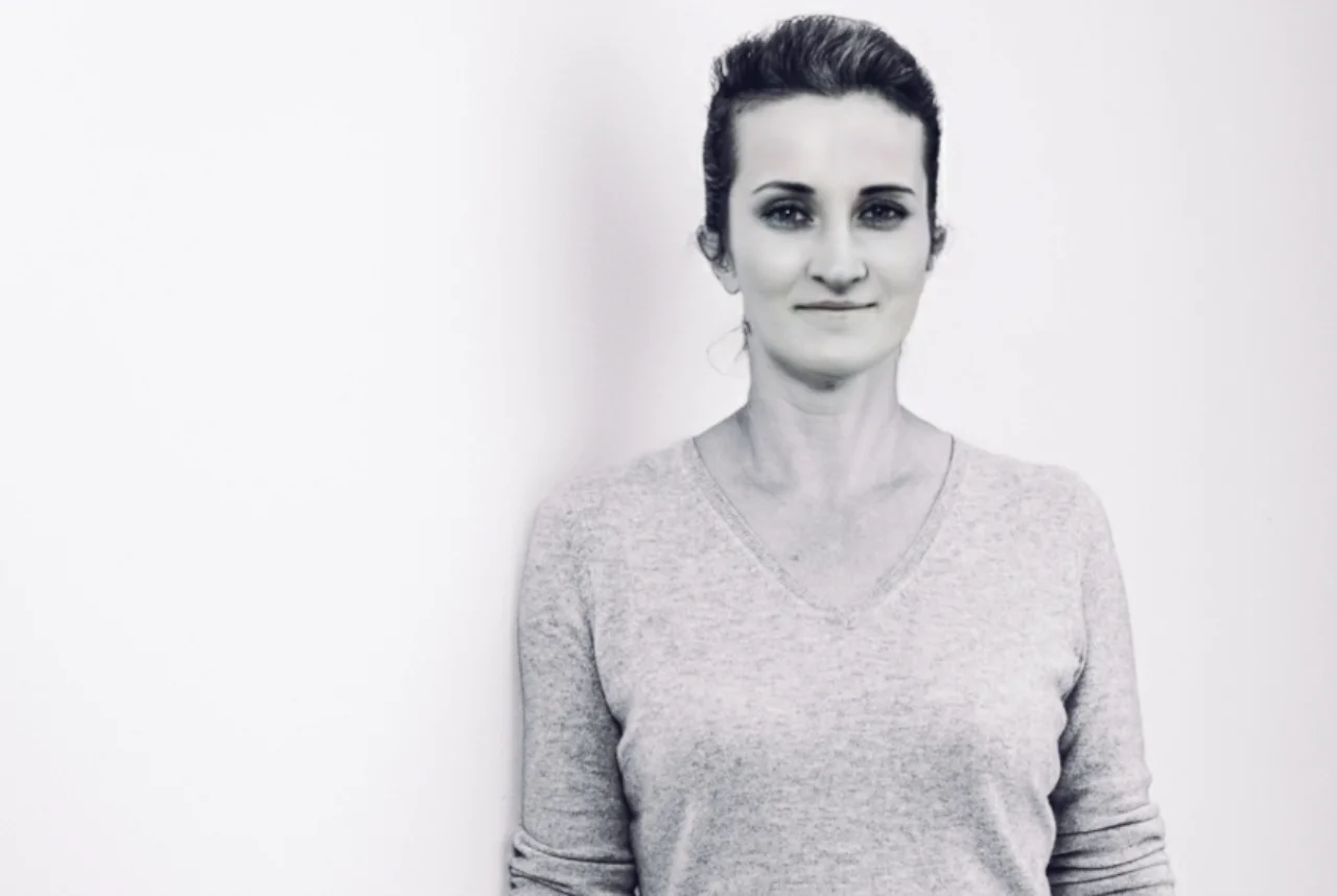 Black and white photo of dark haired woman in gray shirt